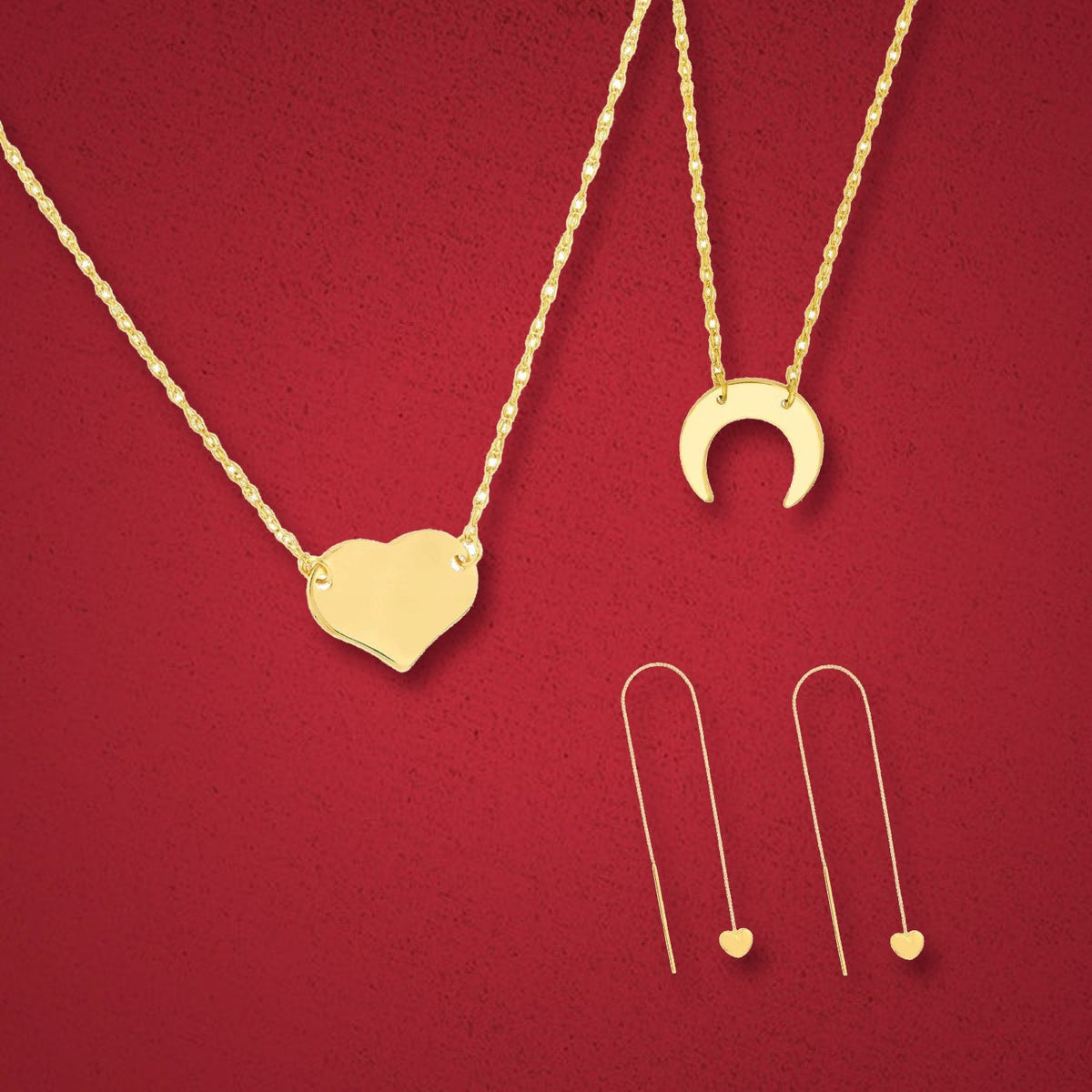 14K gold heart and crescent moon necklaces with heart threader earrings on burgundy