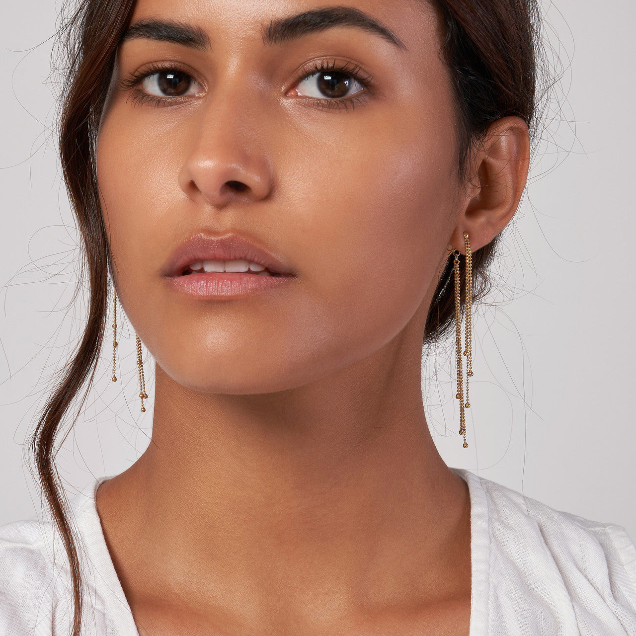 Simple golden raindrop bead earrings by VIA Jewelers, showcasing a delicate design with a shimmering finish.