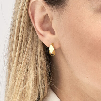 a close up of a geometric earring on woman's ear